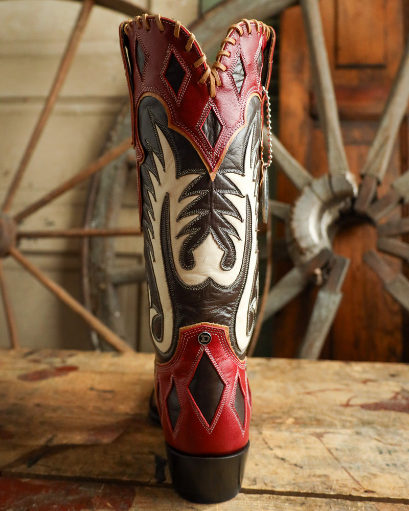 Cowboy boot with intricate design on a wooden surface with a rustic background