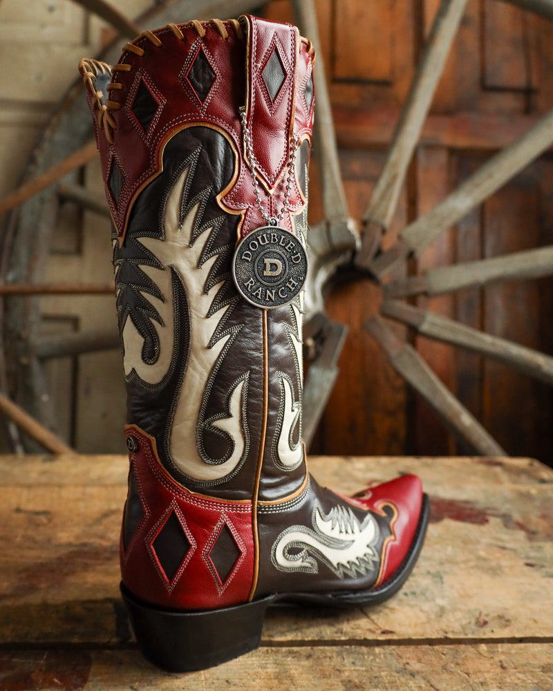 Decorative cowboy boot with intricate patterns on a wooden surface with a rustic background.