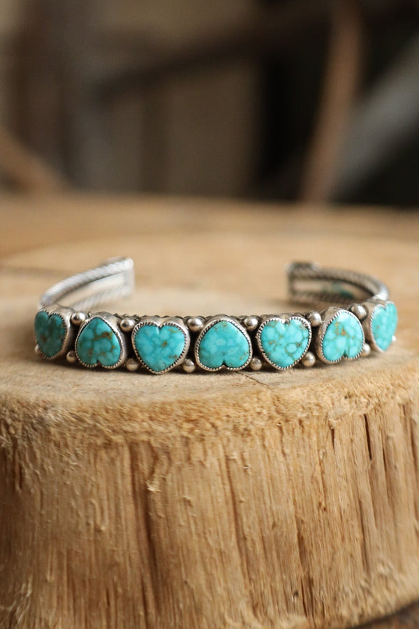 Turquoise bracelet on a wooden surface with a blurred background