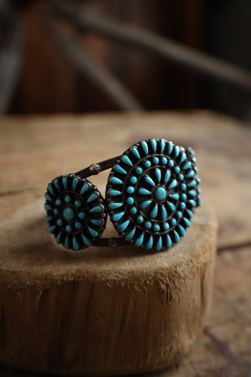 Turquoise beaded bracelet on a wooden surface with a blurred background