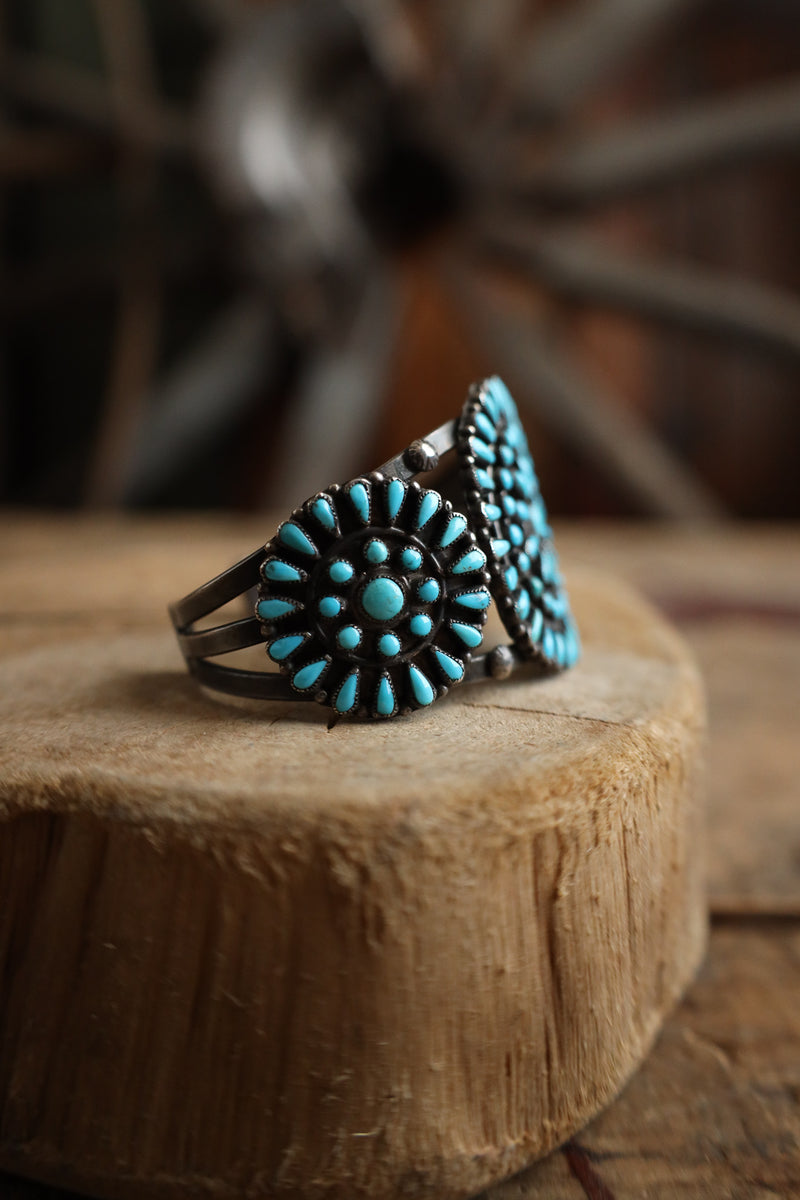 Turquoise stone ring on a wooden surface with a blurred background