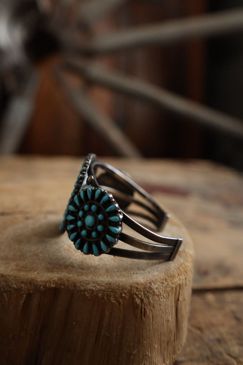 Silver bracelet with turquoise stone on a wooden block
