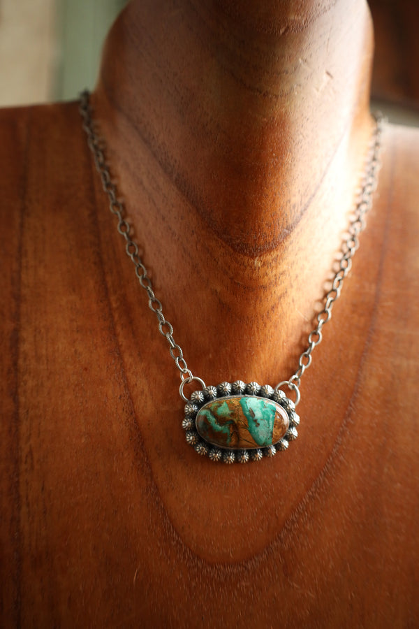 Necklace with a turquoise pendant on a wooden surface
