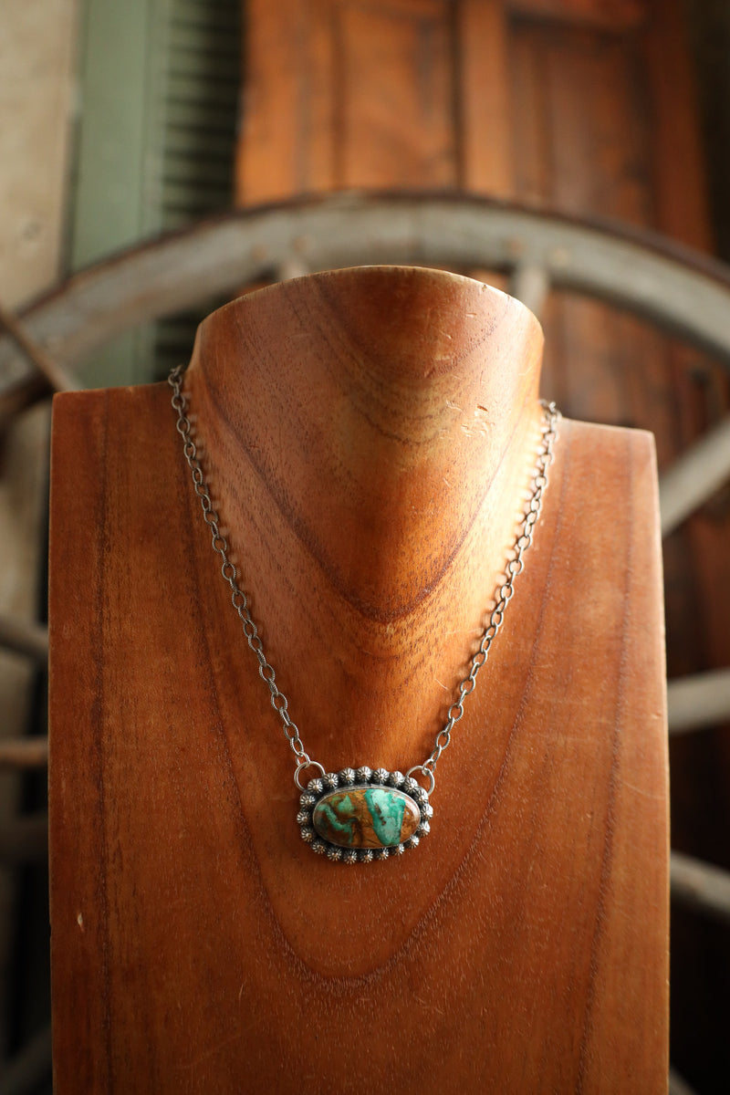 Necklace with a pendant on a wooden stand with a blurred background