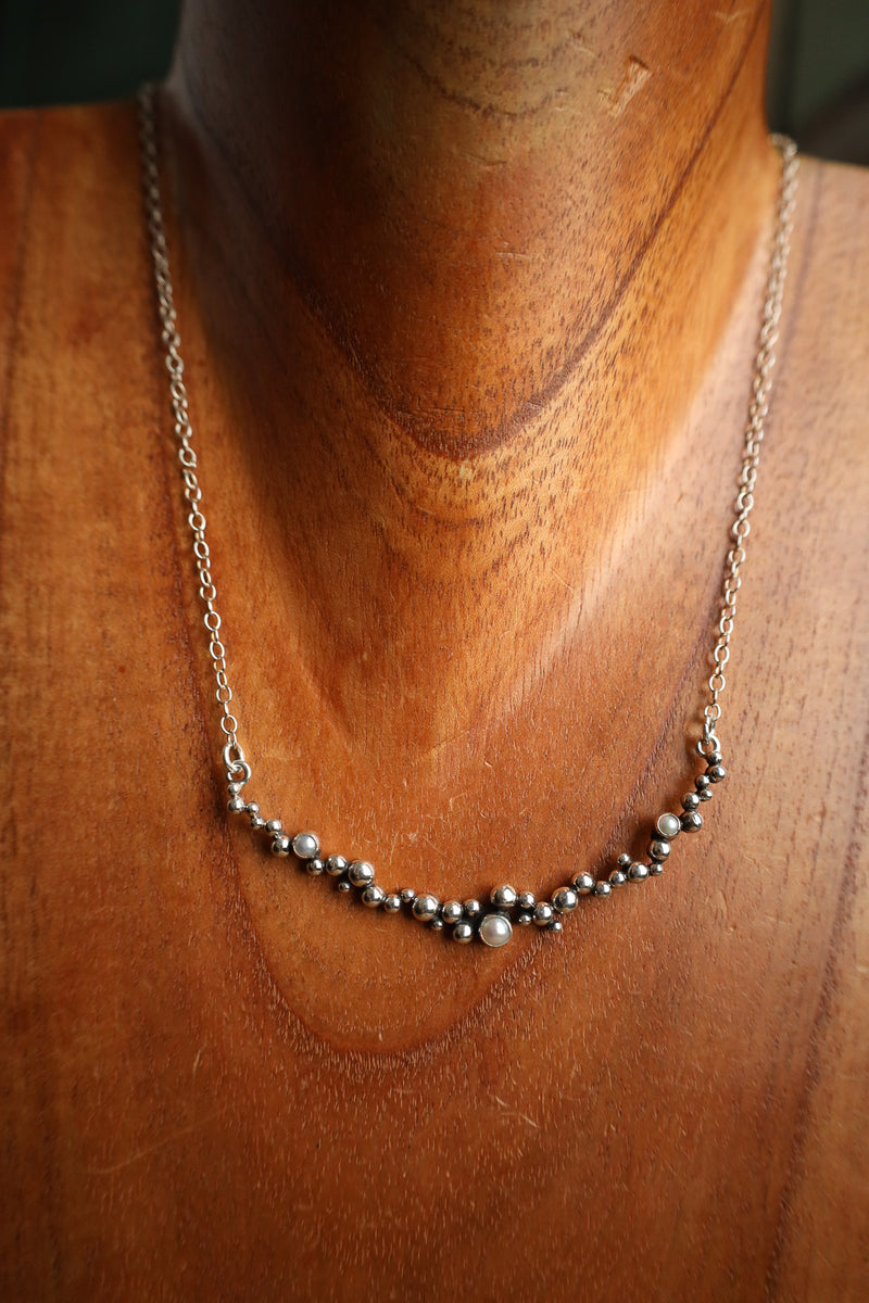 Necklace with small beads on a wooden mannequin