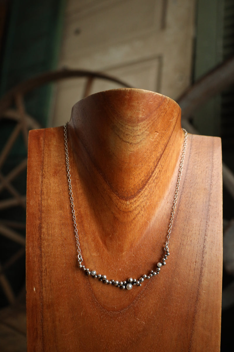 Necklace on a wooden mannequin with a rustic background