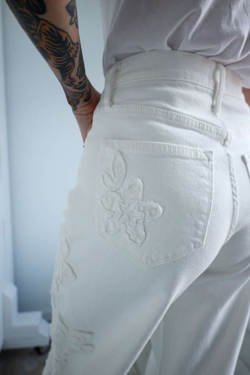 White pants with floral embroidery on a light background