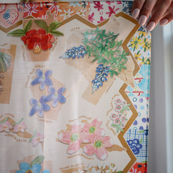 Colorful floral-themed map with hand holding it