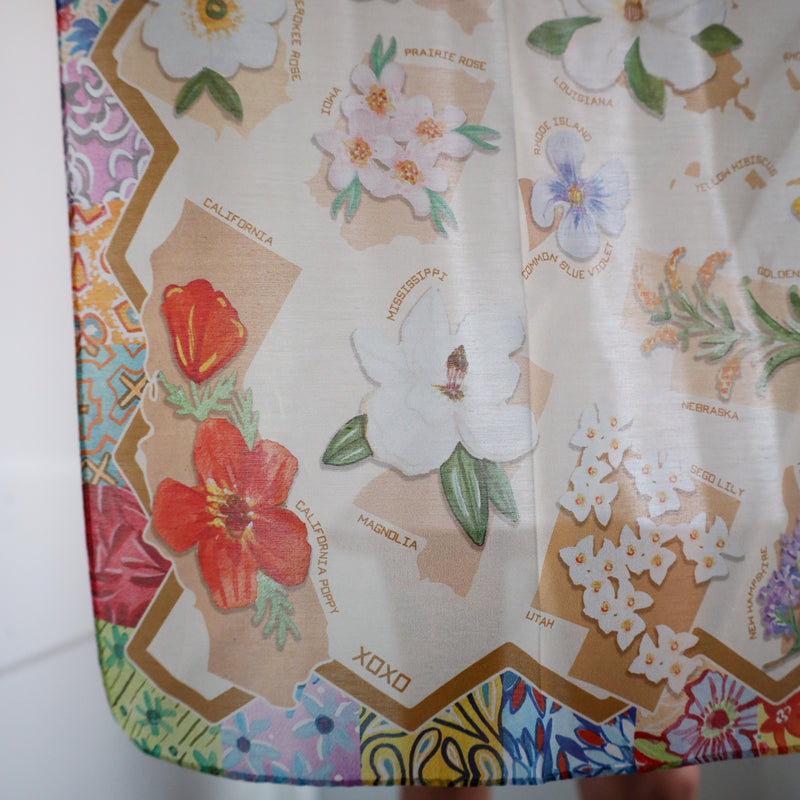 Floral and map design on a fabric or paper with 'XOXO' text.