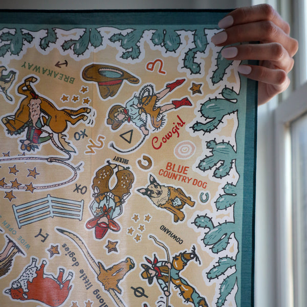 Person holding a framed print with cowboy-themed illustrations