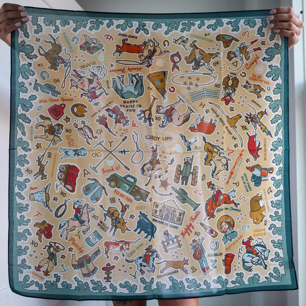 Scarf with cowboy-themed design held by a person