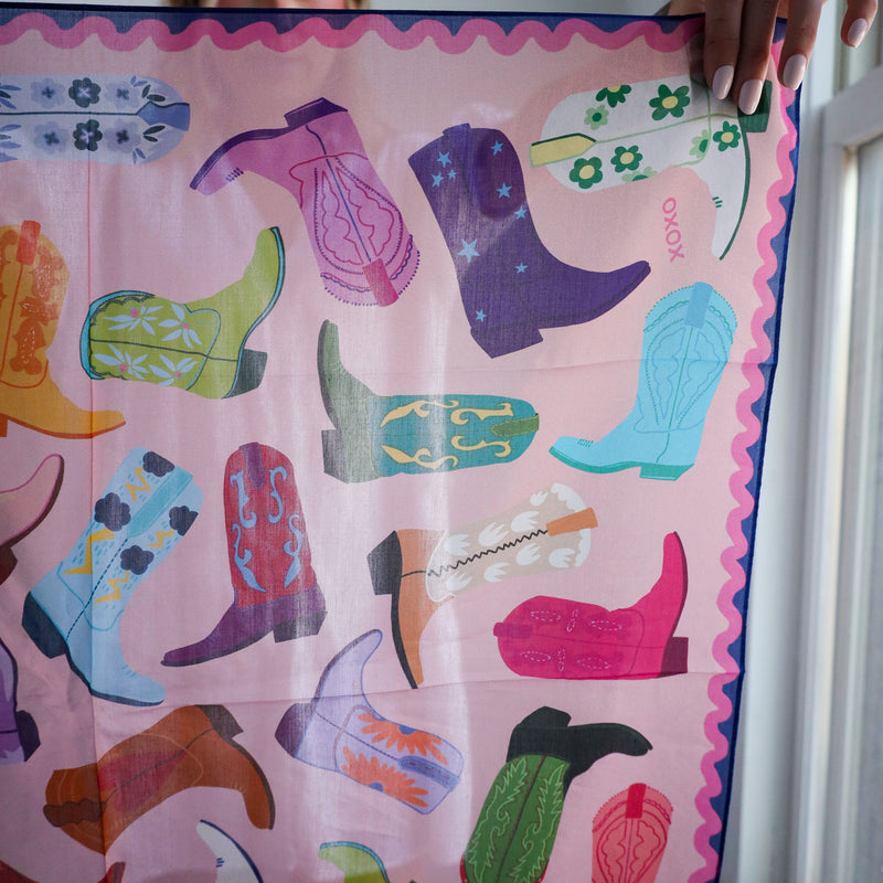 Colorful paper cutouts of boots on a pink background