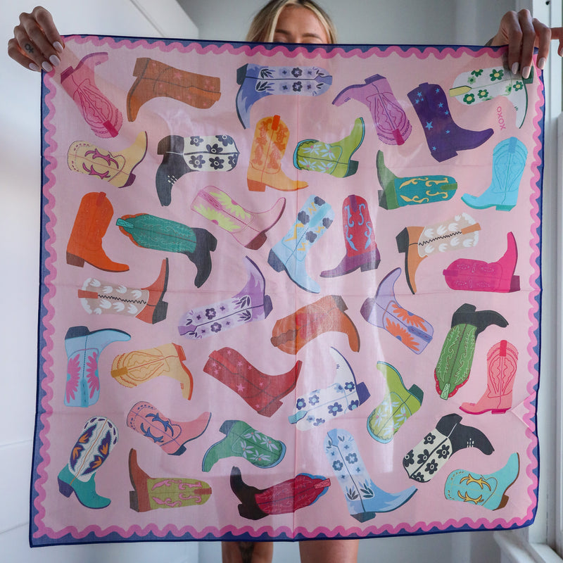 Person holding a colorful scarf with boot pattern