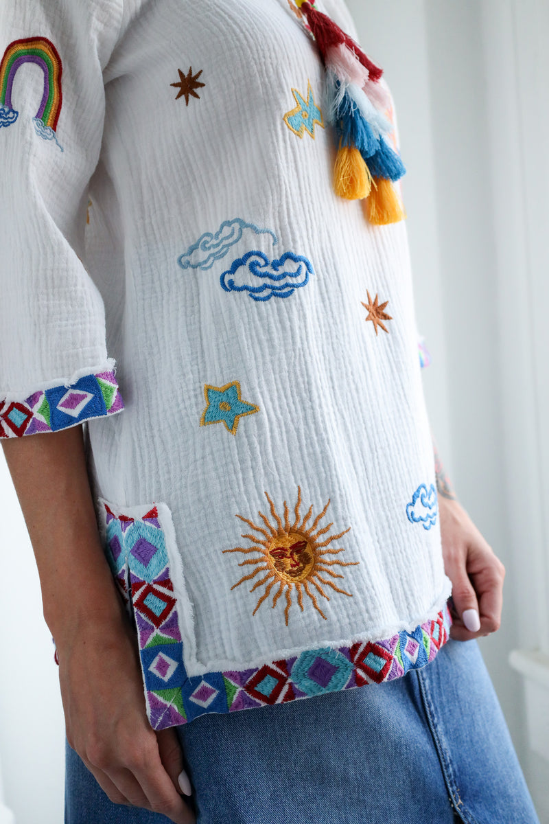 White shirt with colorful embroidered designs on a white background
