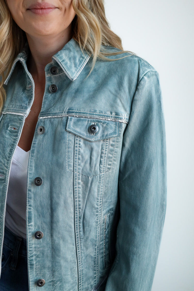 Light blue denim jacket worn by a person on a plain background