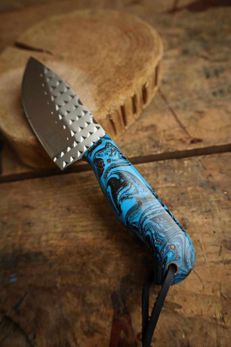 Metal tool with a blue handle on a wooden surface