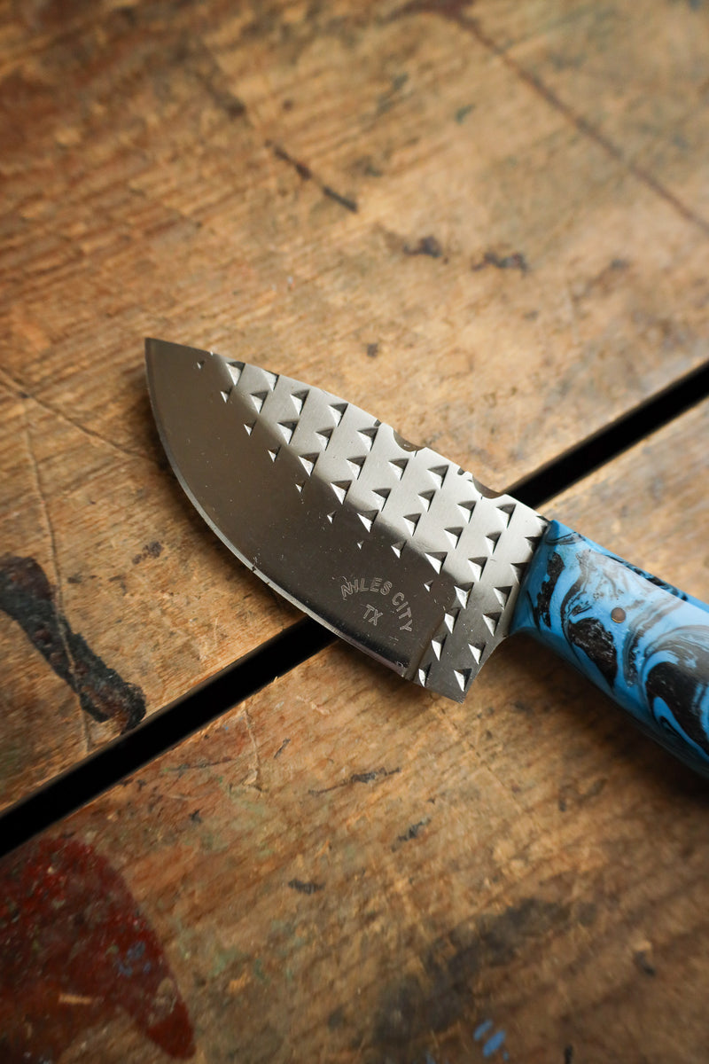 Knife with a blue handle on a wooden surface
