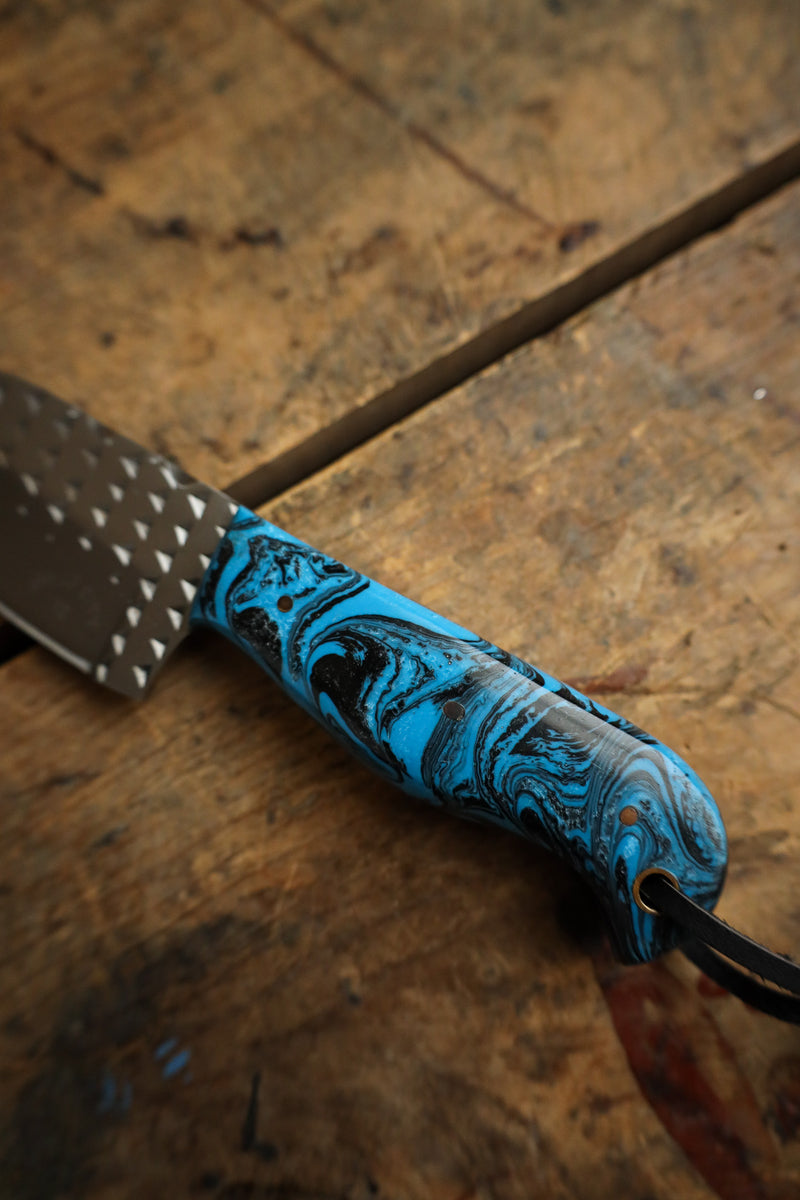 Knife with a blue and black handle on a wooden surface
