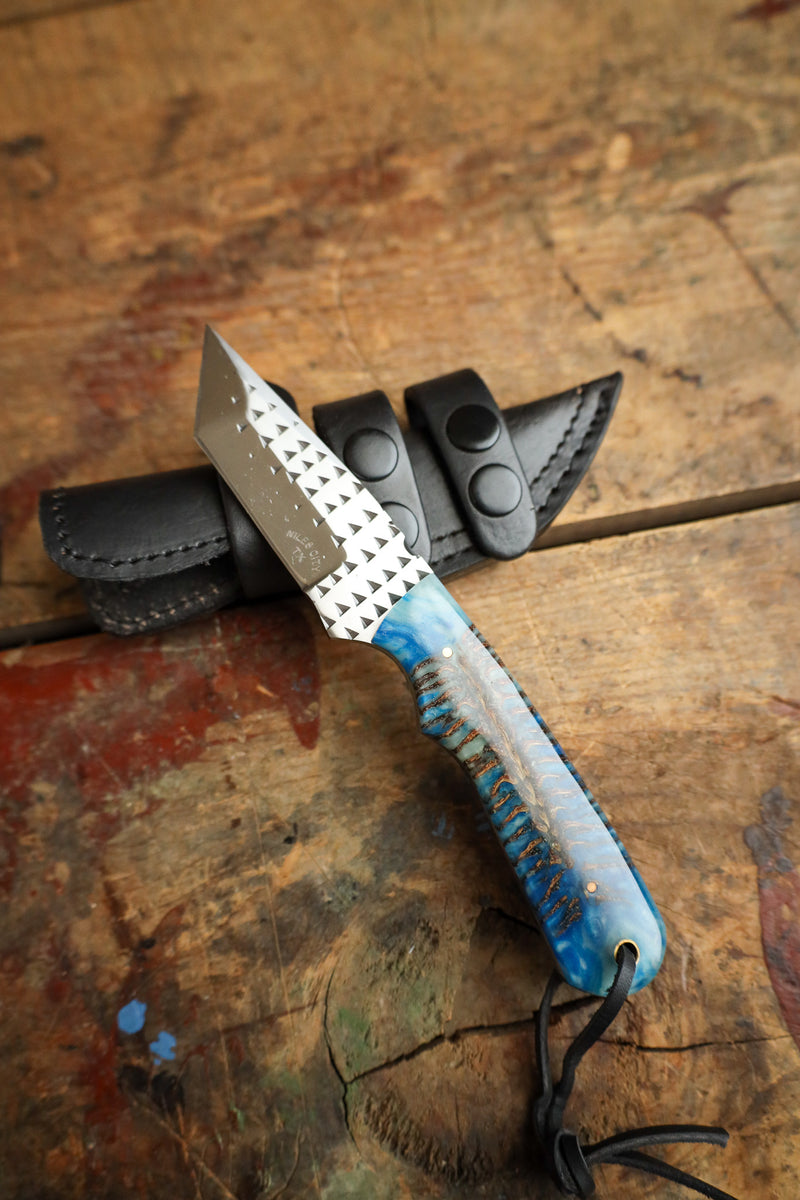 Knife with a blue handle on a wooden surface