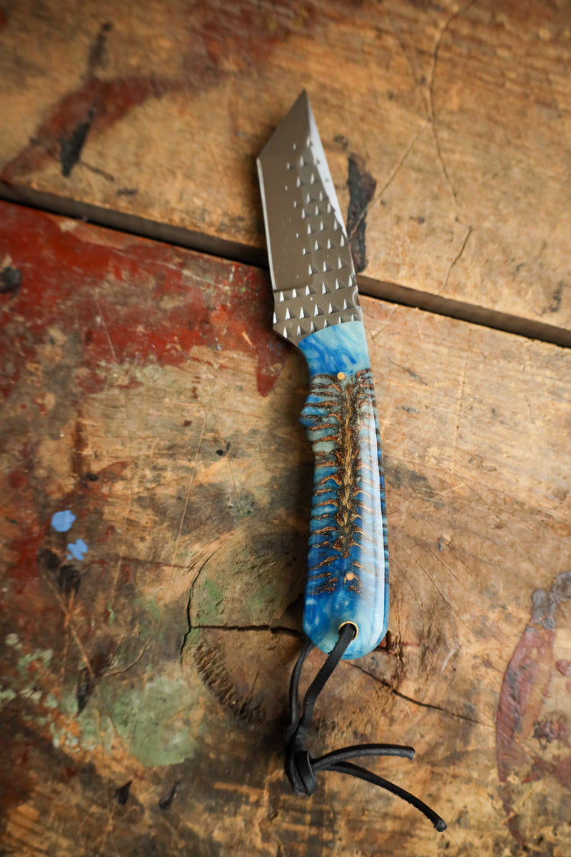 Knife with a blue handle on a wooden surface