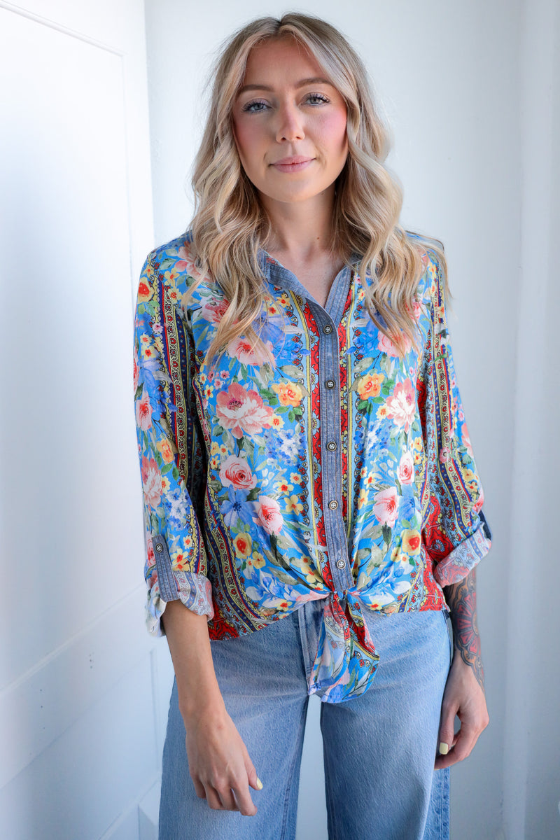 Woman wearing a colorful floral blouse with a white background