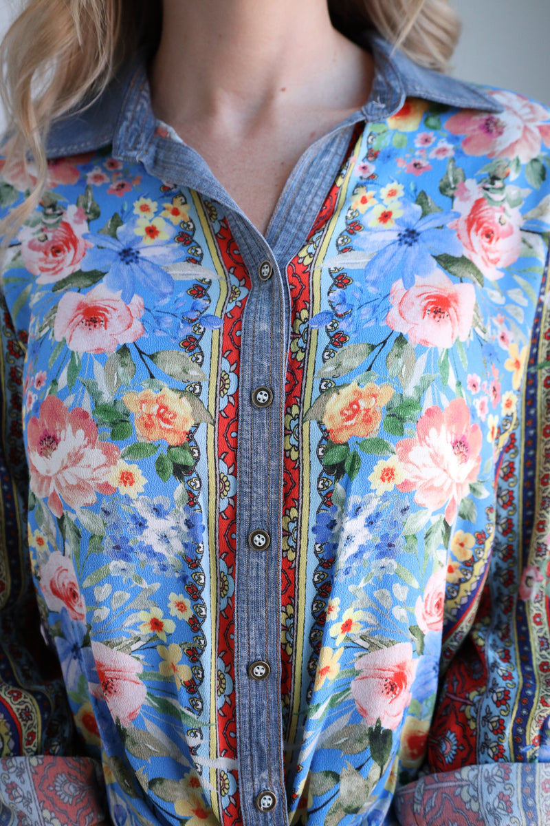 Close-up of a floral shirt with a denim collar and colorful patterns.