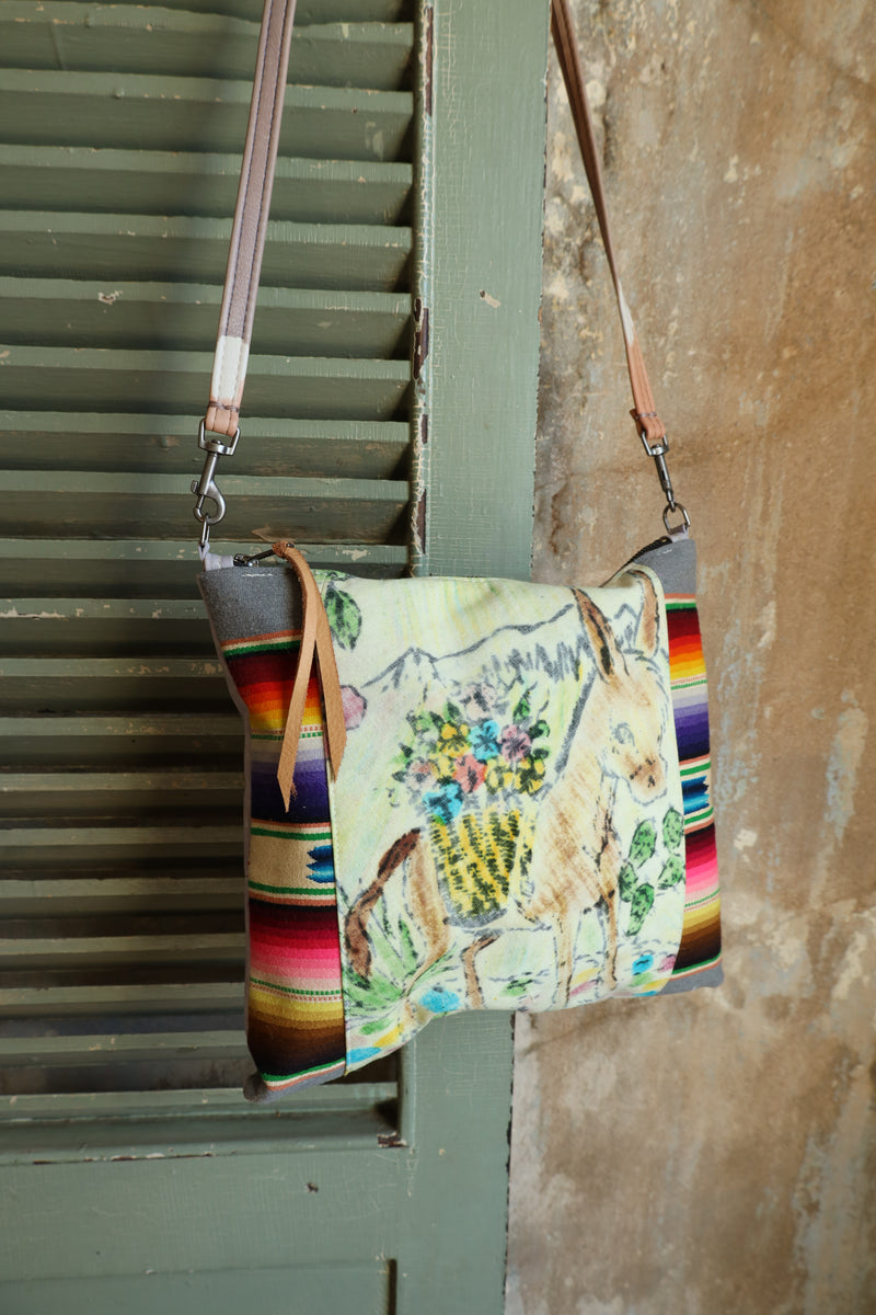 Crossbody purse with burro on front and serape sides. Purse contains a leather back to prevent color transfer with detachable crossbody strap.