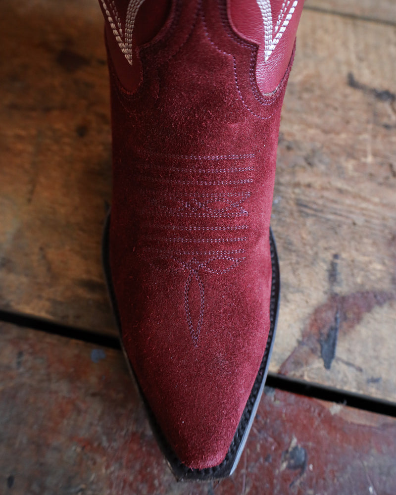 Close-up of a red cowboy boot on a wooden surface