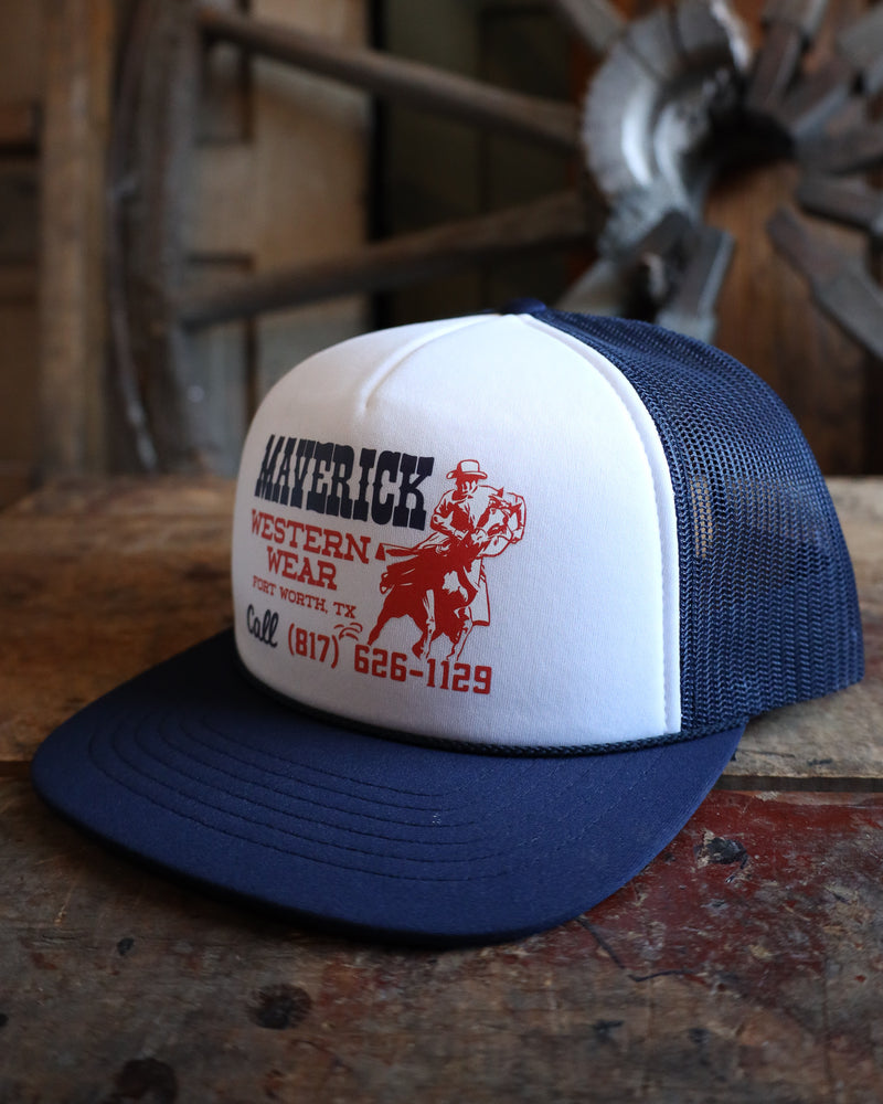 Blue and white trucker hat with red text and graphics on a wooden surface with a rustic background.