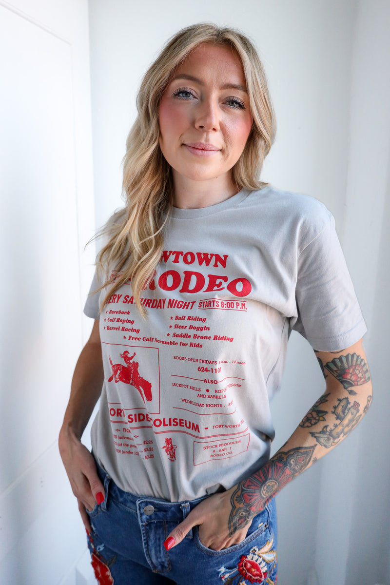 Woman wearing a t-shirt with red text and graphics, standing against a plain background