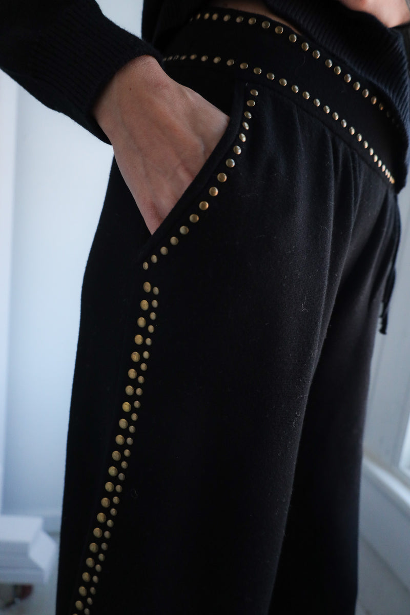Black pants with gold studs on a white background