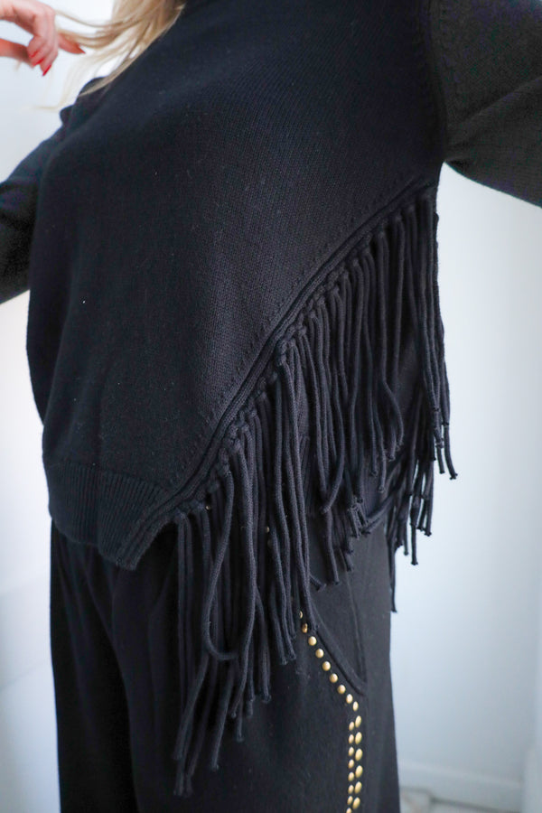 Black fringed sweater with a white background