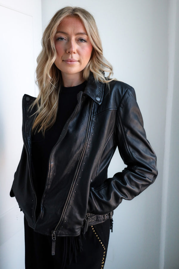 Person wearing a black leather jacket against a white background