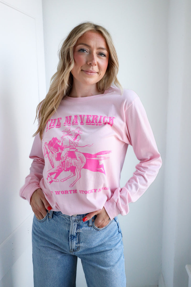 Woman wearing a pink sweatshirt with graphic design and text, standing against a white background