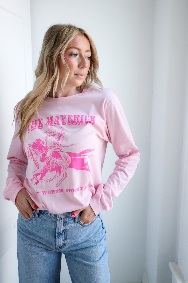 Woman wearing a pink sweatshirt with graphics and text, standing against a white background