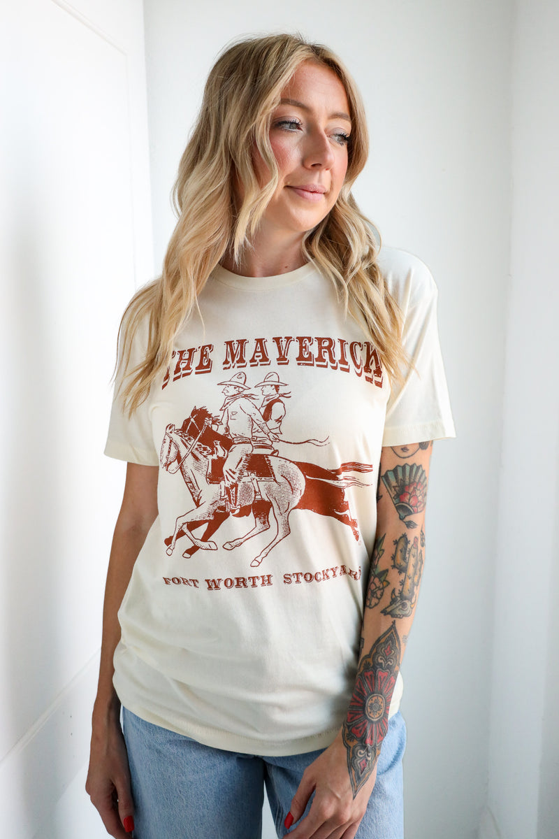 Woman wearing a t-shirt with a graphic design and text, standing against a plain background