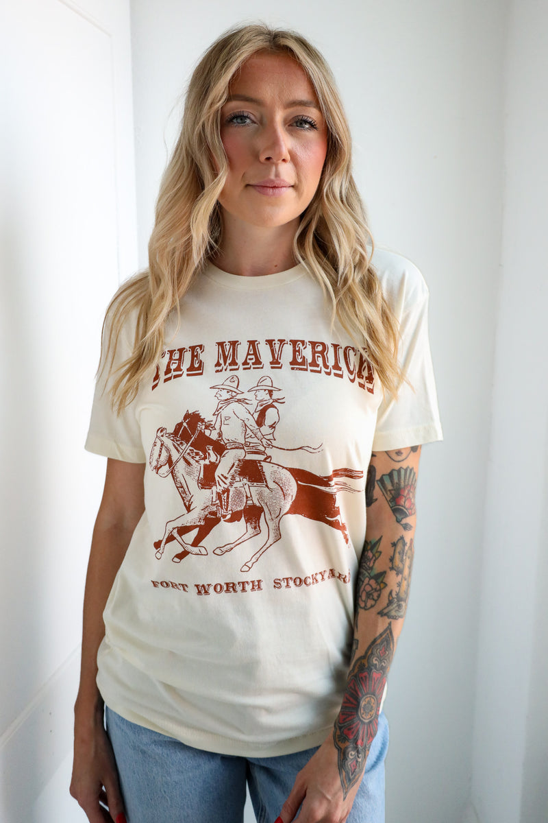 Woman wearing a white t-shirt with a graphic design and text, standing against a plain background.