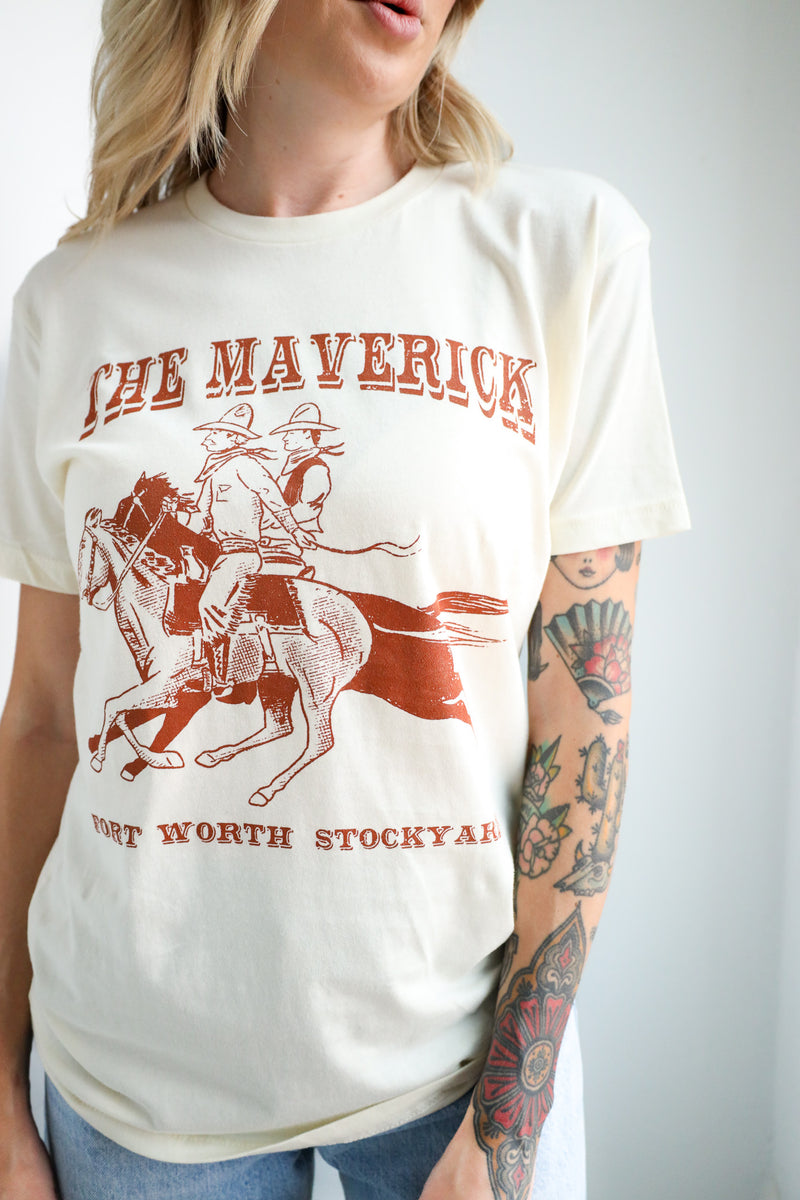 Person wearing a white t-shirt with a graphic of a cowboy and text, on a plain background