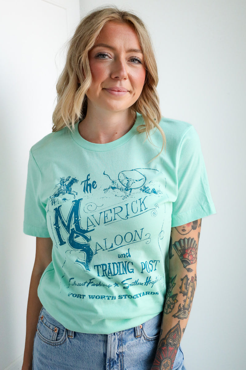 Woman wearing a light blue t-shirt with graphic design and text.