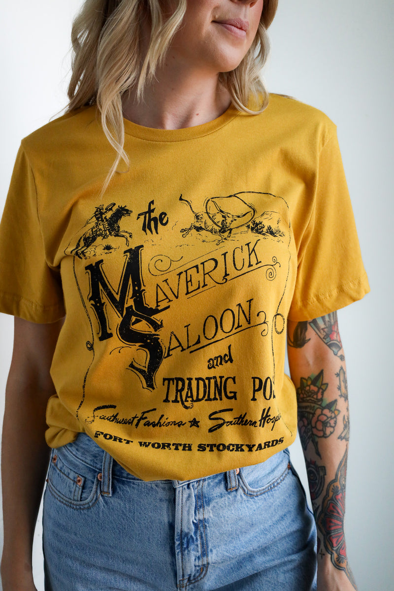 Person wearing a yellow t-shirt with 'Maverick Saloon' graphic design.