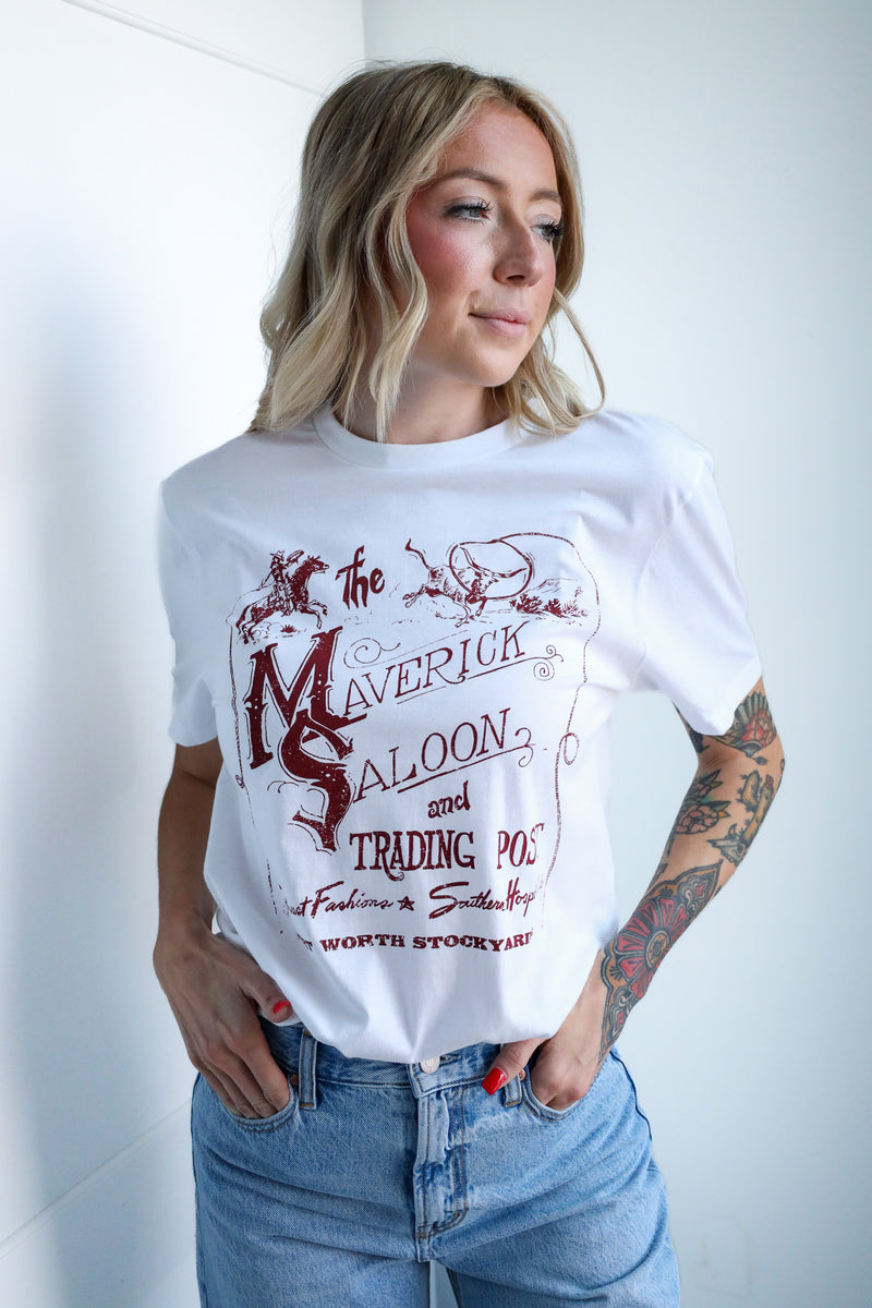 Woman wearing a white t-shirt with a graphic design and blue jeans against a white background