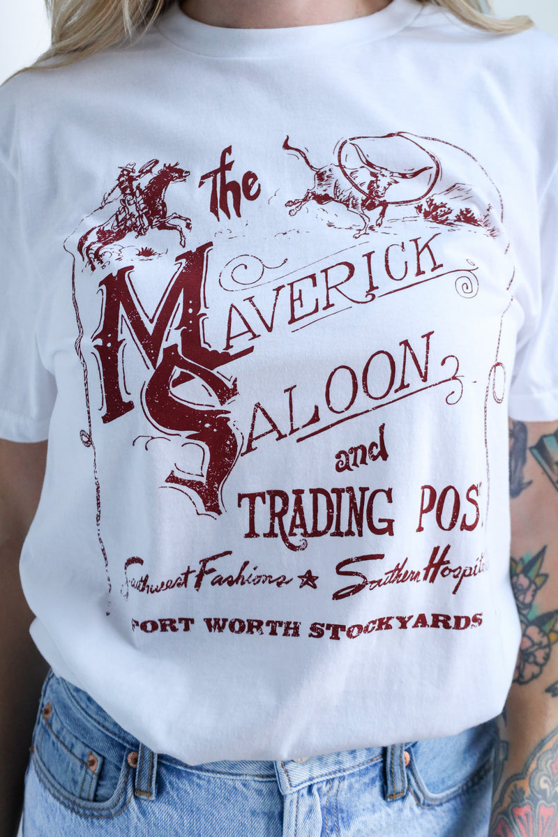 White t-shirt with red graphic design featuring 'The Maverick Saloon and Trading Post' text and logo.
