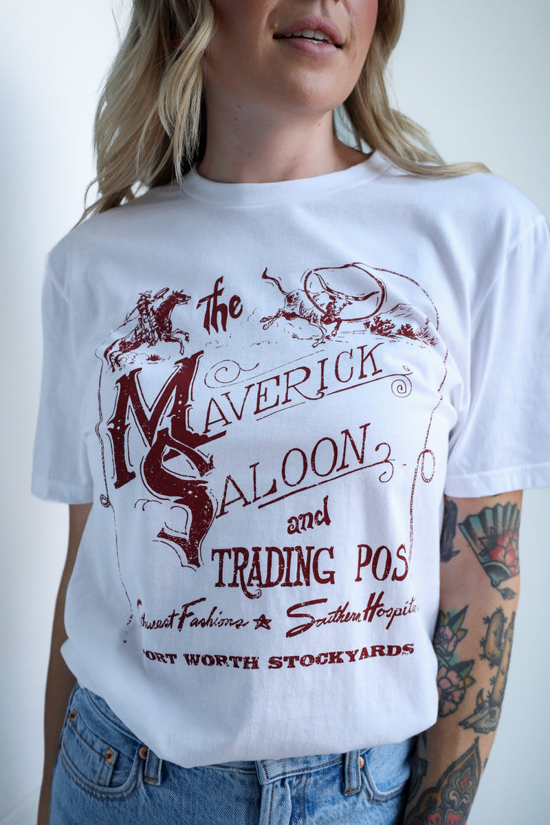Person wearing a white t-shirt with red text and graphics, standing against a plain background.
