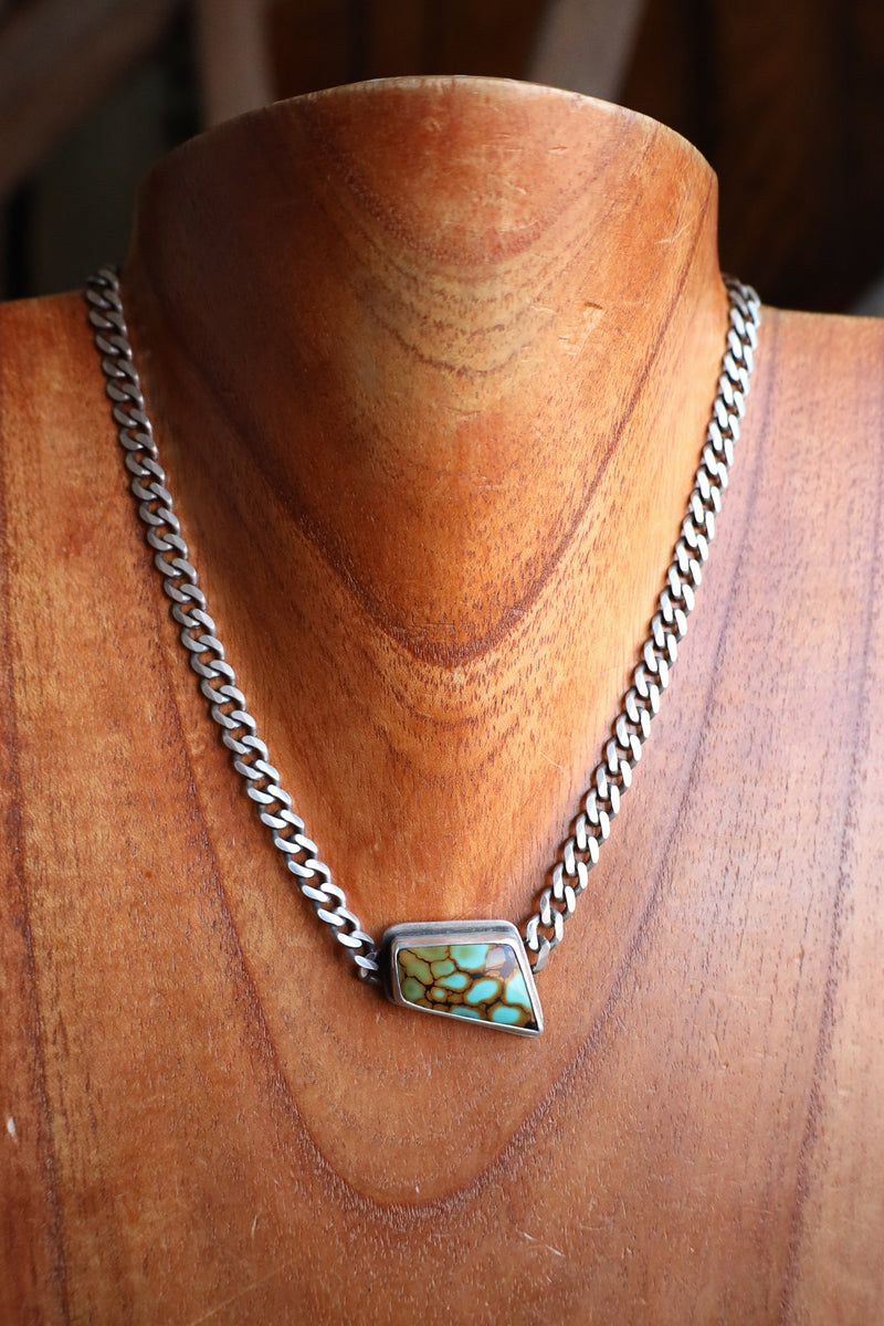 Necklace with a turquoise pendant on a wooden mannequin