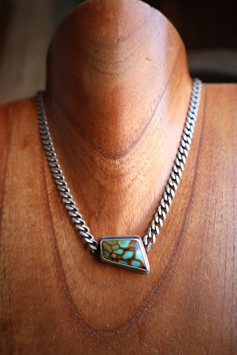 Necklace with a turquoise pendant on a mannequin