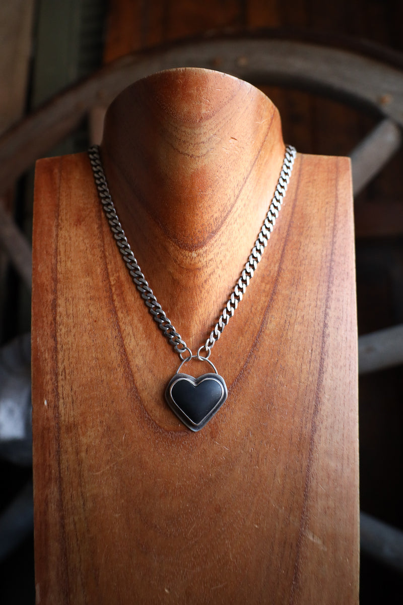 Necklace with a heart-shaped pendant on a wooden stand