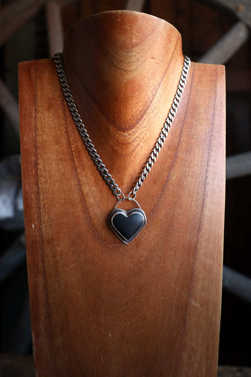 Necklace with a heart-shaped pendant on a wooden stand