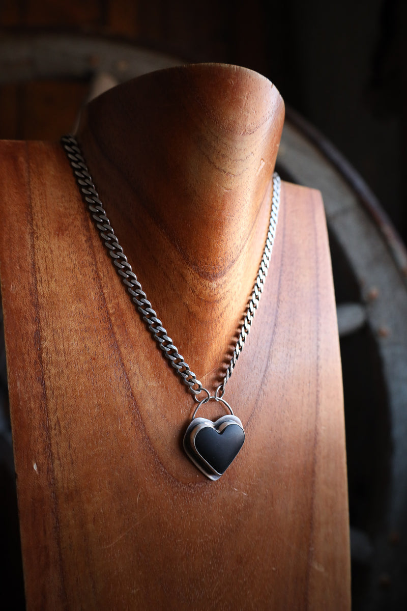 Necklace with a heart-shaped pendant on a wooden stand