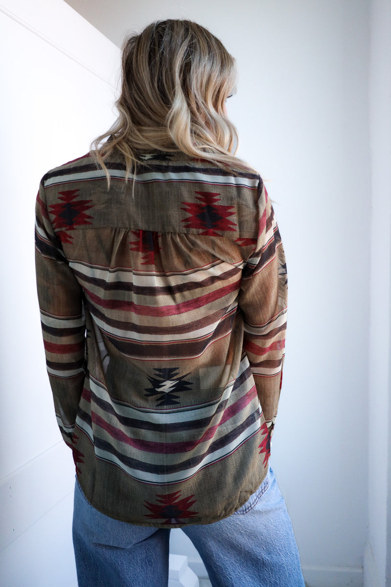 Person wearing a patterned shirt with a plain background