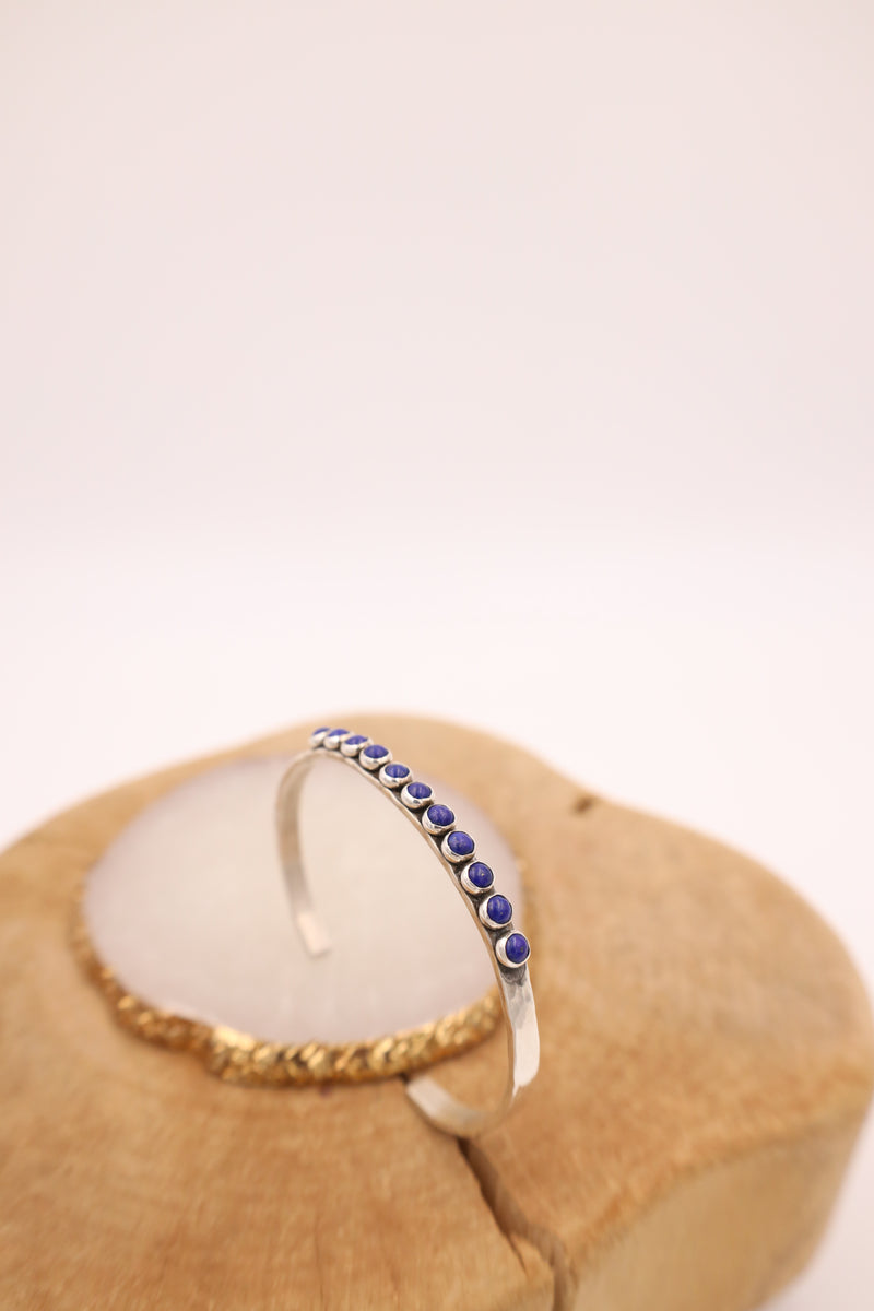 Hammered sterling silver cuff with 11 lapis dots in a line